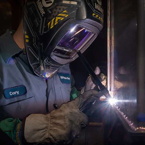 A camp employee welding.