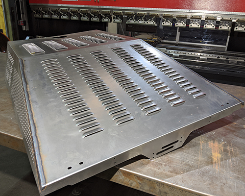 sparks flying as a machine uses laser to cut into a thick piece of metal